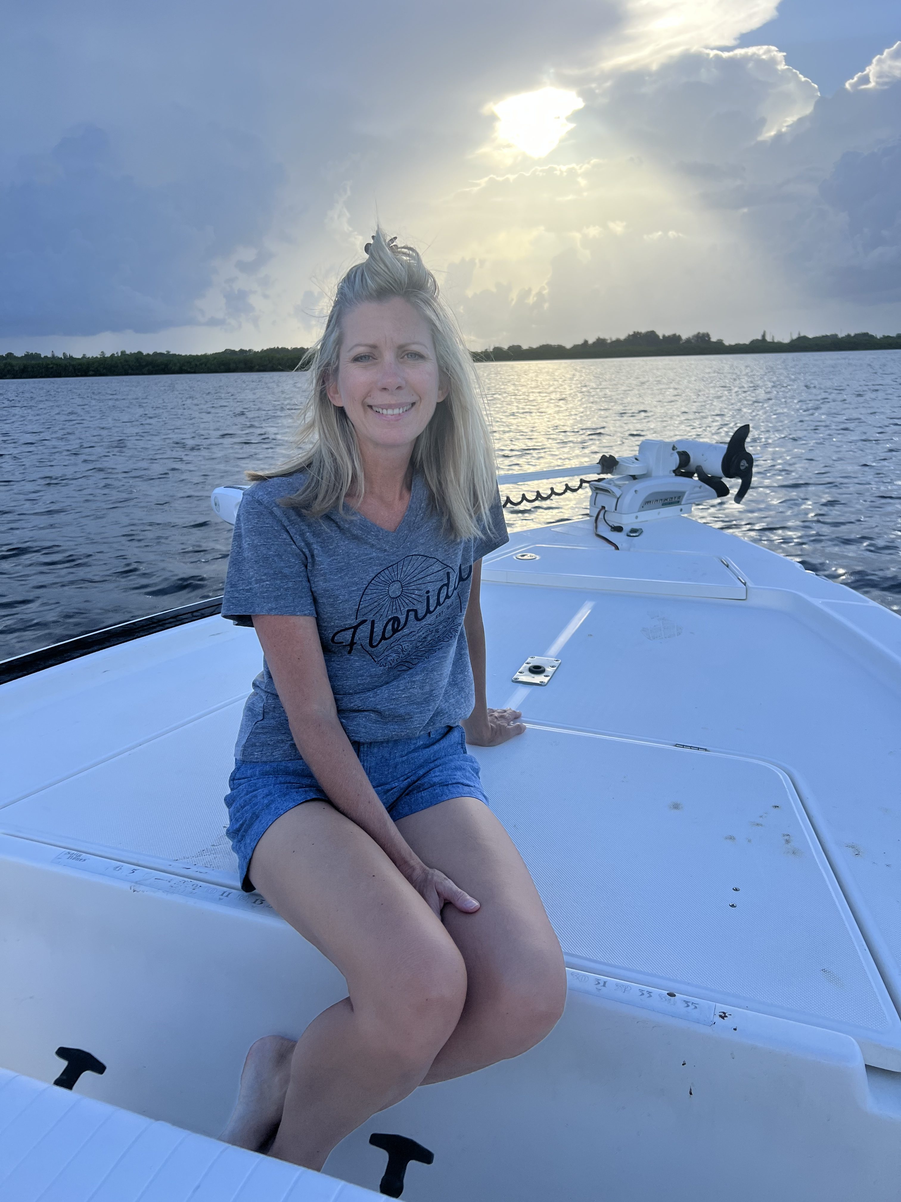 Woman sitting on a boat enjoying the sunset on Tampa Bay with Beyond Fishing Charters.